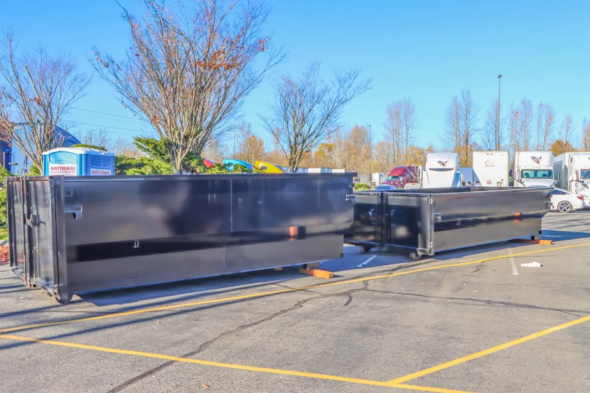 Professional dumpster rental service with roll-off container on residential driveway in Taunton